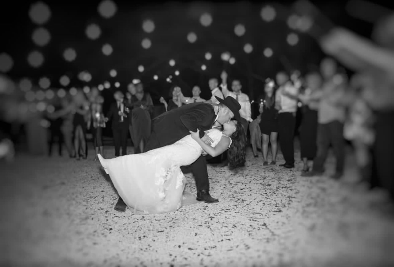 A black-and-white sparkler send-off, the couple in a dip